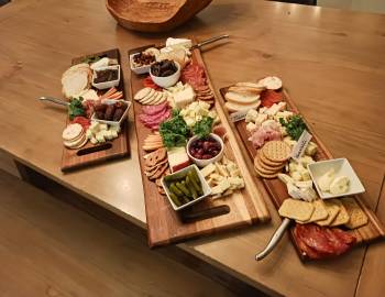 Photo of three charcuterie boards with meat, cheese and fruit.