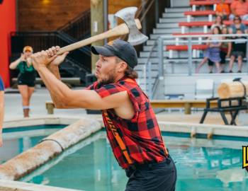Lumberjack performer in a plaid shirt with an axe