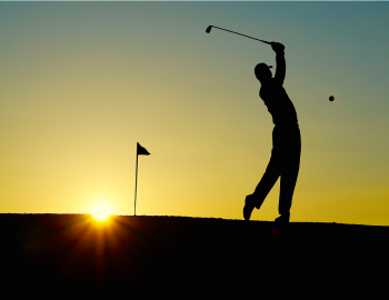Silhouette of a man playing golf